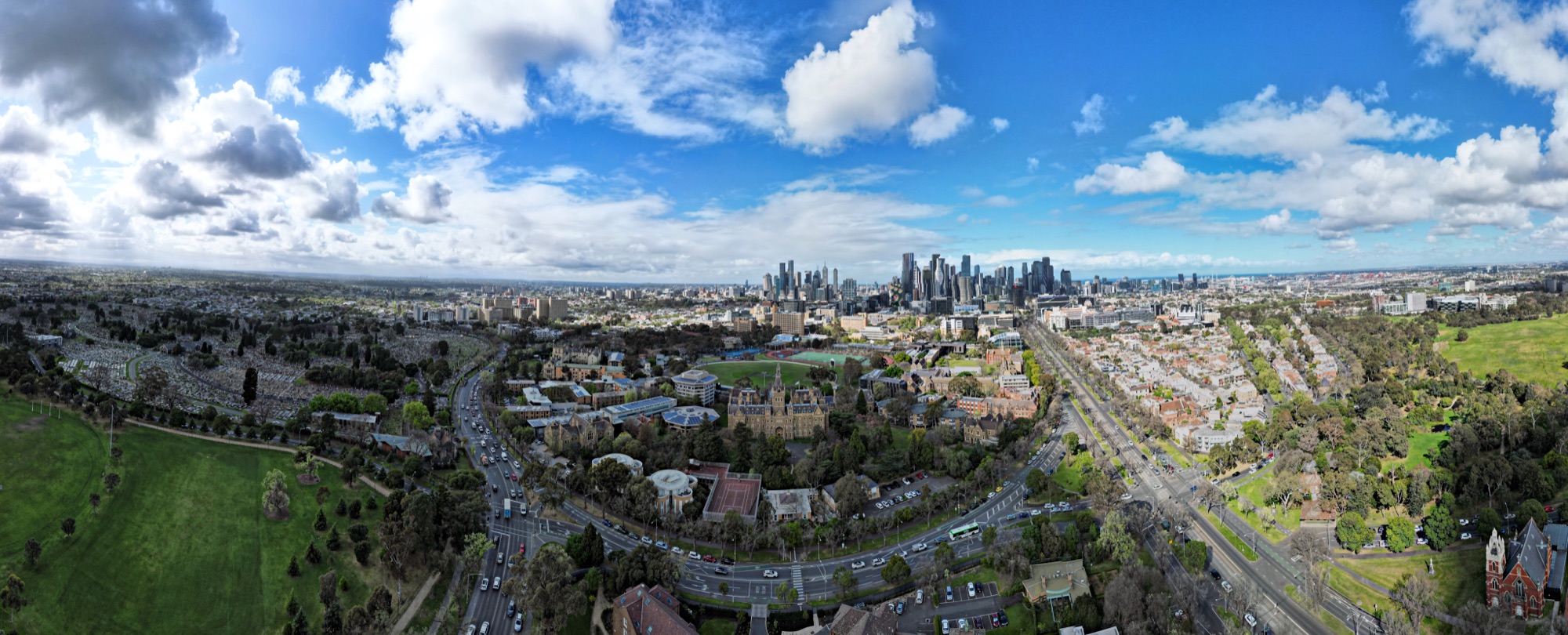 Aerial view across the University of Melbourne campus toward the Melbourne skyline